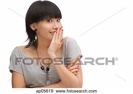 Young woman with hand on mouth, looking at camera View Large Photo Image Stock Photo - Young woman with hand on mouth, looking at camera. Fotosearch