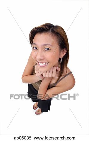 Young woman with hands on chin, smiling up at camera View Large Photo Image Stock Photography - Young woman with hands on chin, smiling up at camera. Fotosearch