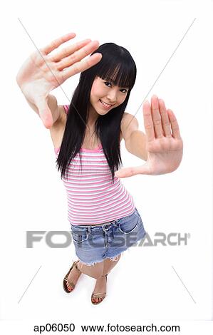 Stock Image - Young woman with hands outstretched, smiling at camera. Fotosearch