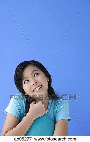 Young woman with pillow, against blue background View Large Photo Image Stock Photo - Young woman with pillow, against blue background. Fotosearch