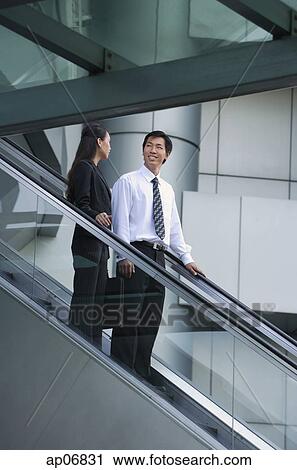 Businessman and businesswoman on escalator View Large Photo Image Stock Image - Businessman and businesswoman on escalator. Fotosearch