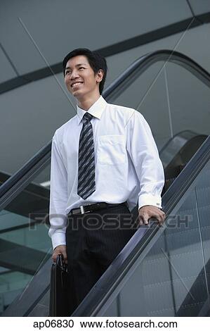 Businessman on escalator, smiling View Large Photo Image Stock Image - Businessman on escalator, smiling. Fotosearch
