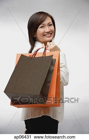 Businesswoman with shopping bags, smiling View Large Photo Image Stock Image - Businesswoman with shopping bags, smiling. Fotosearch