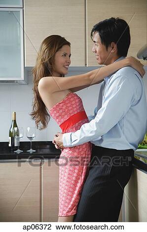 Couple at home, embracing in kitchen View Large Photo Image Stock Image - Couple at home, embracing in kitchen. Fotosearch