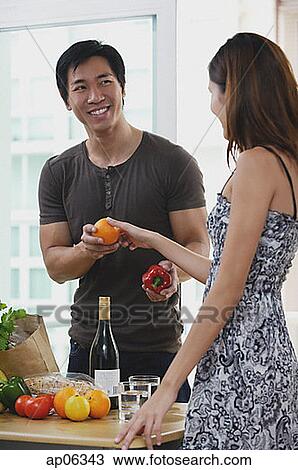 Couple at home, woman passing man a fruit View Large Photo Image Stock Image - Couple at home, woman passing man a fruit. Fotosearch
