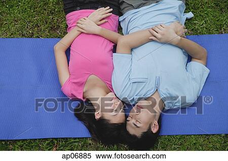 Couple in park, lying on mat, eyes closed View Large Photo Image Stock Photography - Couple in park, lying on mat, eyes closed. Fotosearch