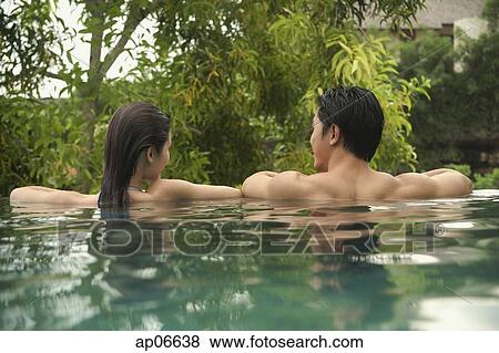 Couple in swimming pool, rearview View Large Photo Image Stock Photo - Couple in swimming pool, rearview. Fotosearch