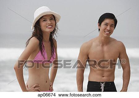 Couple on beach, looking at camera, smiling View Large Photo Image Picture - Couple on beach, looking at camera, smiling. Fotosearch