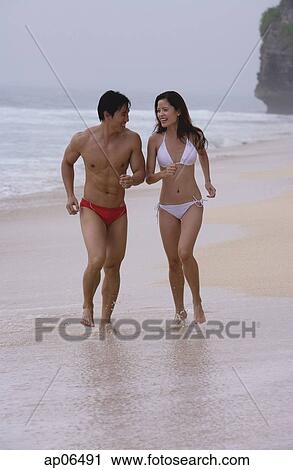 Couple running along beach View Large Photo Image Stock Image - Couple running along beach. Fotosearch