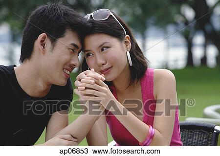 Couple sitting side by side, face to face, holding hands View Large Photo Image Stock Image - Couple sitting side by side, face to face, holding hands. Fotosearch