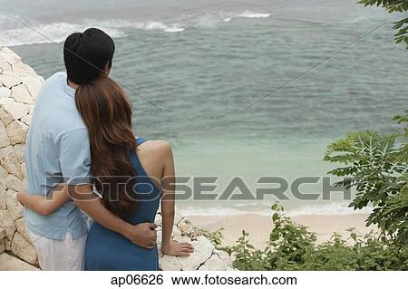 Couple standing side by side looking out at sea, rear view View Large Photo Image Stock Photograph - Couple standing side by side looking out at sea, rear view. Fotosearch