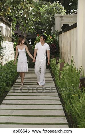 Couple walking along path in garden, holding hands View Large Photo Image Stock Photography - Couple walking along path in garden, holding hands. Fotosearch