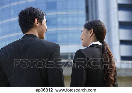 Executives standing side by side, talking, rear view View Large Photo Image Stock Image - Executives standing side by side, talking, rear view. Fotosearch