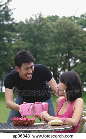 Man giving woman a gift View Large Photo Image Stock Photo - Man giving woman a gift. Fotosearch
