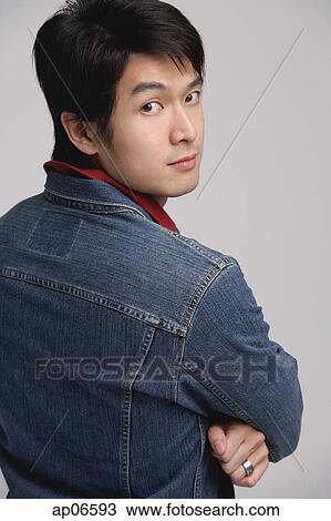 Man in denim jacket, arms crossed, looking over shoulder View Large Photo Image Stock Image - Man in denim jacket, arms crossed, looking over shoulder. Fotosearch
