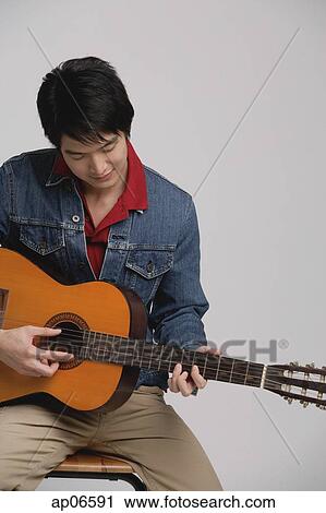 Man in denim jacket, playing guitar View Large Photo Image Stock Image - Man in denim jacket, playing guitar. Fotosearch