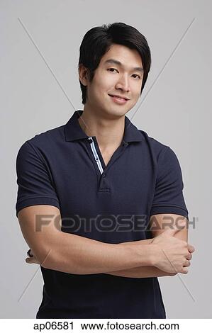 Man in polo shirt, looking at camera, arms crossed View Large Photo Image Stock Image - Man in polo shirt, looking at camera, arms crossed. Fotosearch