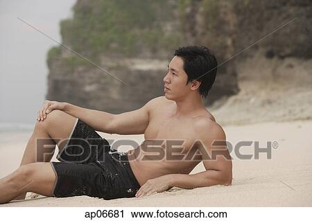 Man lying on beach, looking away View Large Photo Image Stock Image - Man lying on beach, looking away. Fotosearch