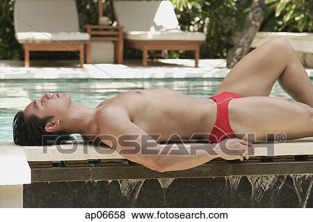 Man lying on edge of swimming pool View Large Photo Image Stock Photo - Man lying on edge of swimming pool. Fotosearch