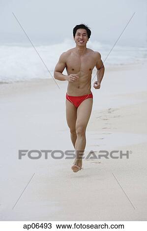 Man running along beach View Large Photo Image Stock Image - Man running along beach. Fotosearch