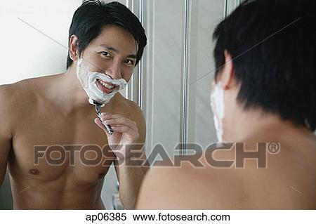 Man shaving, looking at camera through mirror reflection View Large Photo Image Stock Photography - Man shaving, looking at camera through mirror reflection. Fotosearch