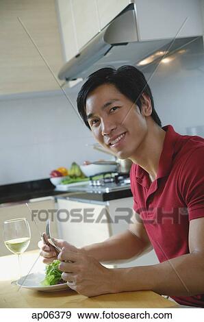 Man sitting down for a meal, smiling at camera View Large Photo Image Stock Photo - Man sitting down for a meal, smiling at camera. Fotosearch