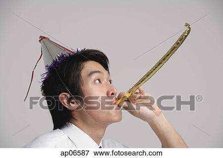 Man wearing party hat and using noisemaker View Large Photo Image Stock Photo - Man wearing party hat and using noisemaker. Fotosearch