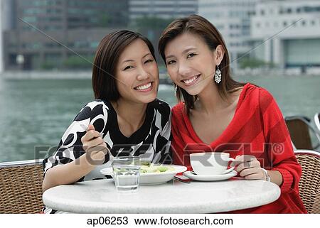Two women at sidewalk cafe having lunch, smiling at camera View Large Photo Image Stock Image - Two women at sidewalk cafe having lunch, smiling at camera. Fotosearch