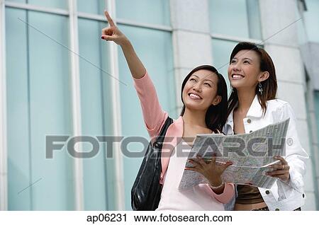 Two women with map, looking up View Large Photo Image Stock Image - Two women with map, looking up. Fotosearch
