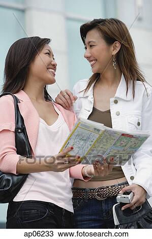 Two women with map, smiling at each other View Large Photo Image Stock Image - Two women with map, smiling at each other. Fotosearch