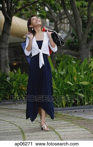 Woman carrying shopping bags, looking up View Large Photo Image Stock Image - Woman carrying shopping bags, looking up. Fotosearch