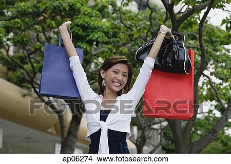 Picture - Woman carrying shopping bags, smiling. Fotosearch