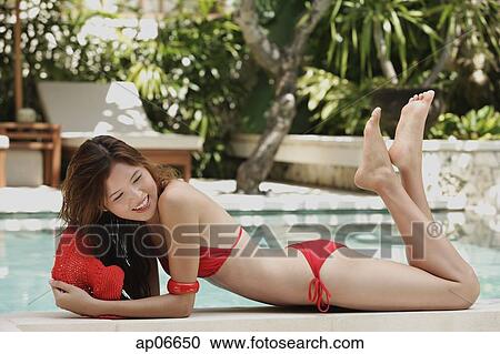 Woman in red bikini and hat, lying at the edge of swimming pool, smiling View Large Photo Image Stock Image - Woman in red bikini and hat, lying at the edge of swimming pool, smiling. Fotosearch