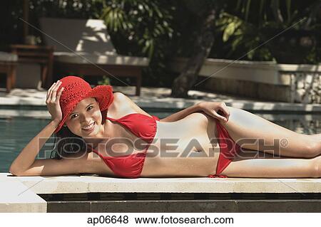 Woman in red bikini and hat, lying at the edge of swimming pool View Large Photo Image Stock Photo - Woman in red bikini and hat, lying at the edge of swimming pool. Fotosearch