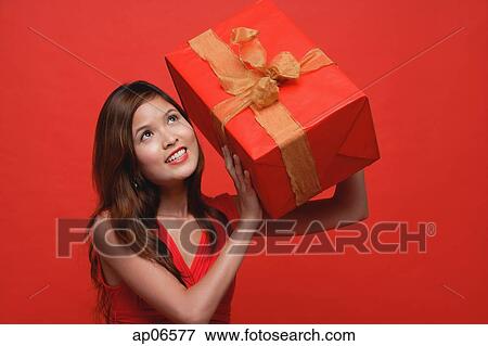 Woman in red dress, holding wrapped gift box View Large Photo Image Stock Photo - Woman in red dress, holding wrapped gift box. Fotosearch