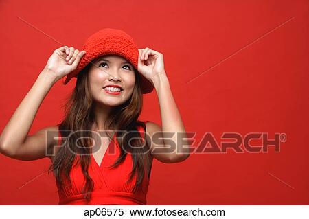 Woman in red dress with red hat against red background, smiling View Large Photo Image Stock Photography - Woman in red dress with red hat against red background, smiling. Fotosearch
