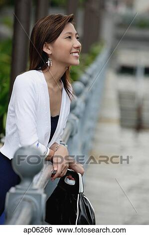 Woman leaning on railing, looking away View Large Photo Image Stock Photograph - Woman leaning on railing, looking away. Fotosearch