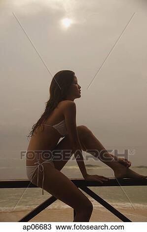Woman sitting on beach, looking away View Large Photo Image Stock Image - Woman sitting on beach, looking away. Fotosearch
