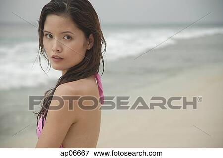 Woman standing on beach, looking at camera View Large Photo Image Stock Photo - Woman standing on beach, looking at camera. Fotosearch