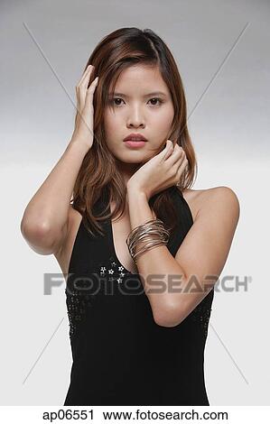 Woman touching her hair, hand on chin, looking at camera View Large Photo Image Stock Image - Woman touching her hair, hand on chin, looking at camera. Fotosearch