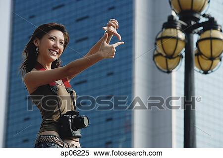 Woman with camera, framing a shot with her fingers View Large Photo Image Stock Photography - Woman with camera, framing a shot with her fingers. Fotosearch