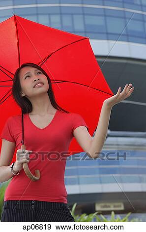 Woman with red umbrella, looking up, frowning View Large Photo Image Stock Photo - Woman with red umbrella, looking up, frowning. Fotosearch