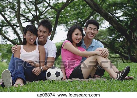 Young adults in park, smiling at camera View Large Photo Image Picture - Young adults in park, smiling at camera. Fotosearch