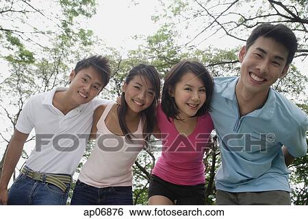 Young adults in park, smiling at camera View Large Photo Image Stock Photograph - Young adults in park, smiling at camera. Fotosearch