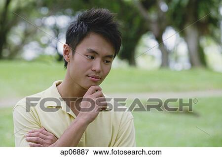 Young man with hand on chin View Large Photo Image Stock Photo - Young man with hand on chin. Fotosearch