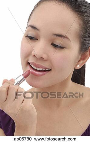 Young woman applying lipstick View Large Photo Image Stock Image - Young woman applying lipstick. Fotosearch