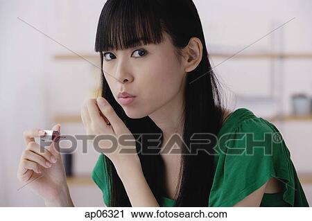 Young woman applying nail polish, blowing on nails View Large Photo Image Stock Image - Young woman applying nail polish, blowing on nails. Fotosearch