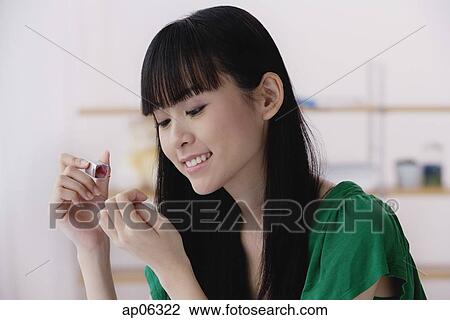 Young woman applying nail polish View Large Photo Image Stock Image - Young woman applying nail polish. Fotosearch
