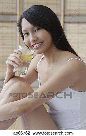 Young woman drinking from glass of water View Large Photo Image Stock Image - Young woman drinking from glass of water. Fotosearch