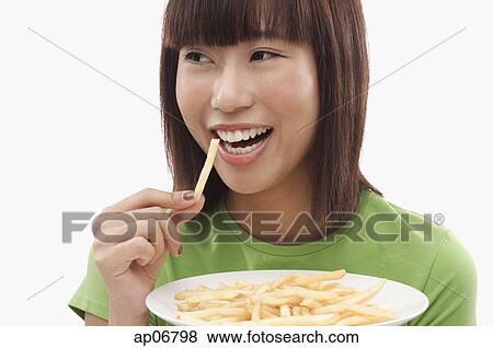 Young woman eating French fries View Large Photo Image Stock Photo - Young woman eating French fries. Fotosearch